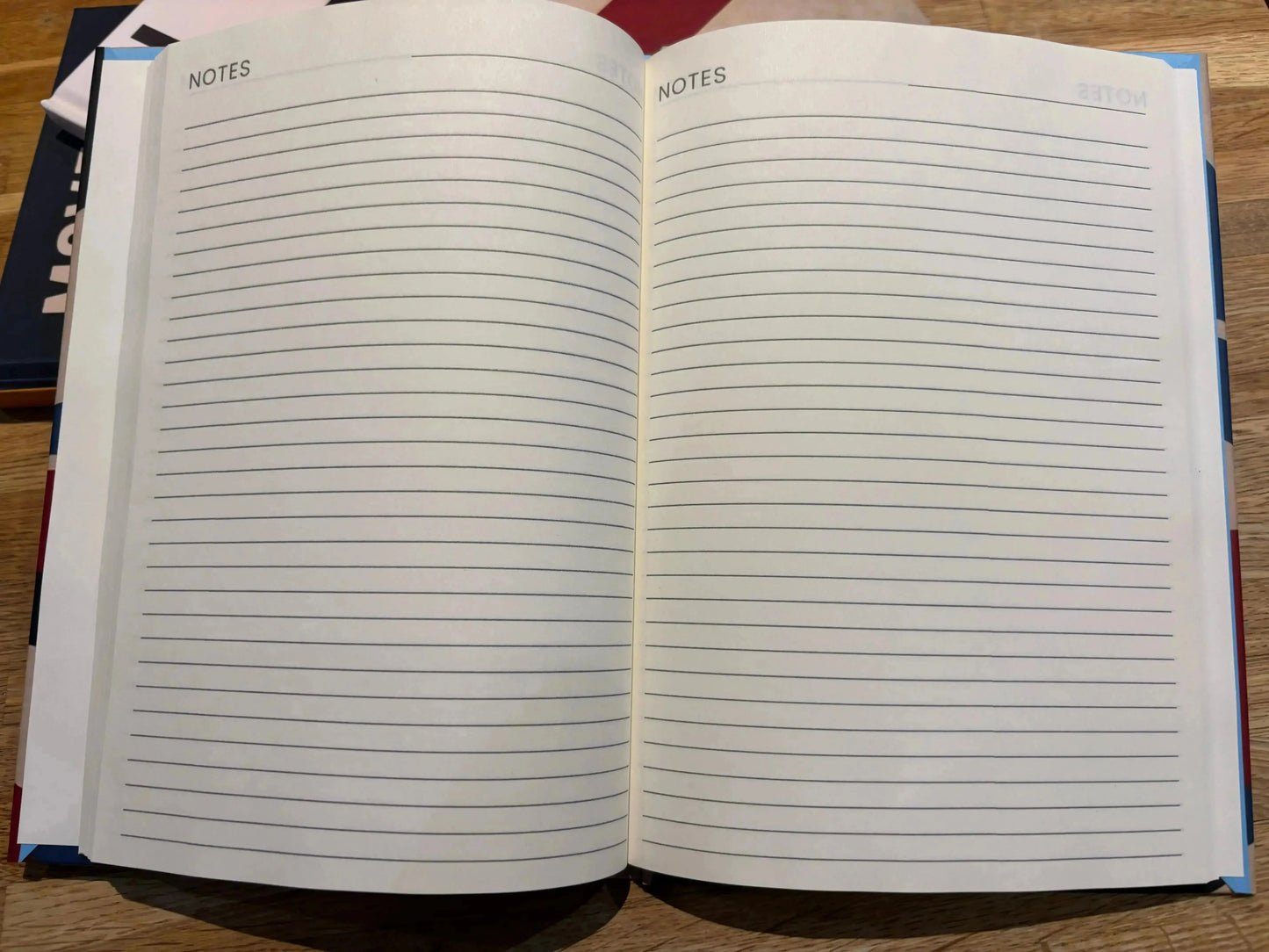 Open notebook with lined pages on a wooden surface