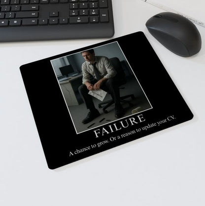 Mouse mat with the text “FAILURE – A chance to grow. Or a reason to update your CV” showing a dejected man holding a resignation letter — humorous office desk accessory.